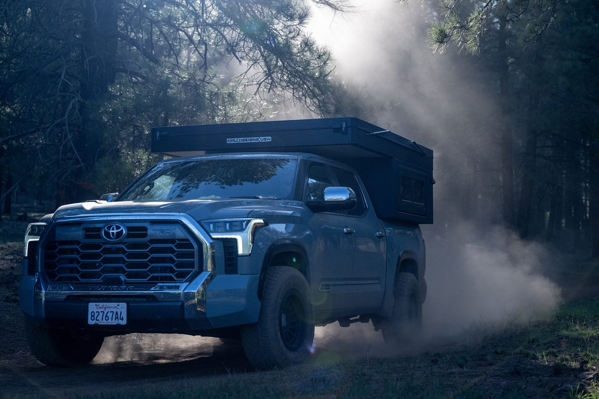 Oru Bruin XL on a Toyota Tundra powering through dust on a forest trail at dusk